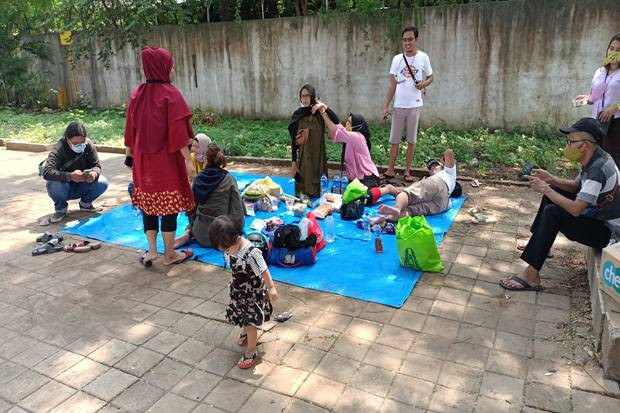 Penutupan Ancol yang dilakukan mendadak  membuat keluarga ini berlibur di pinggir jalan. (Foto: MNC Media)