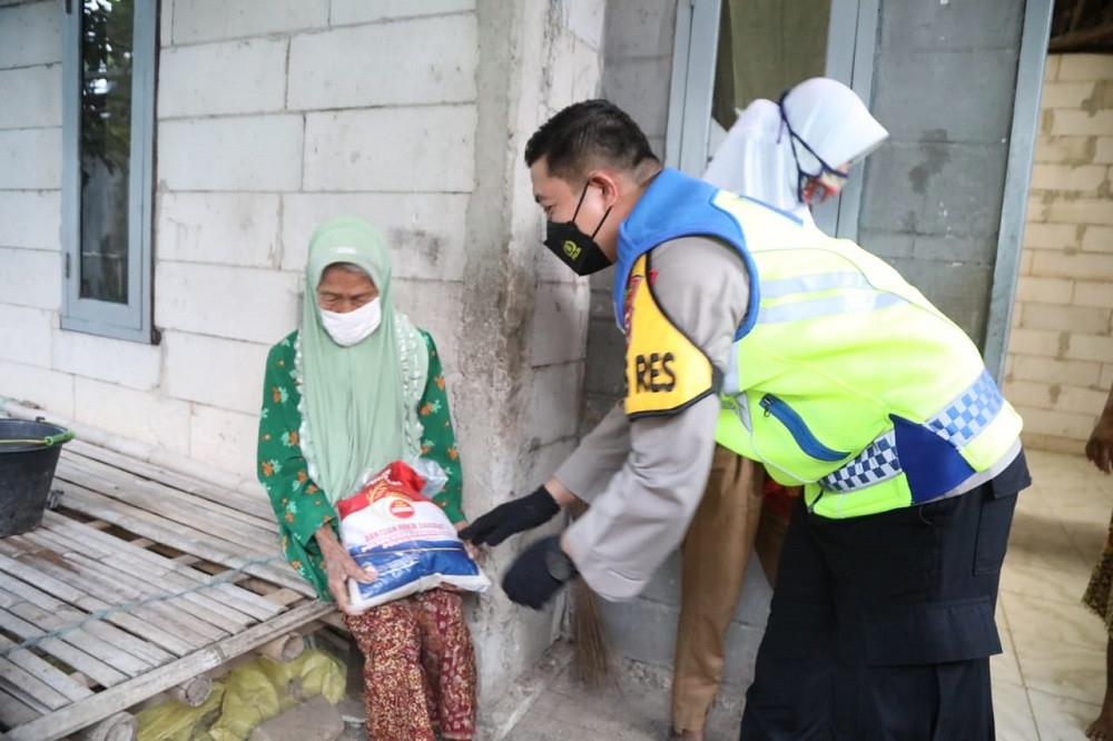 Polisi memberikan bansos beras 5kg kepada masyarakat miskin di Tangerang/Hasan Kurniawan (SINDO)