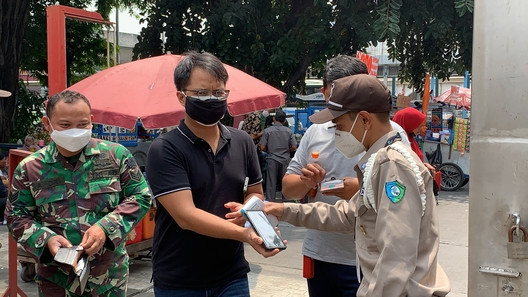Petugas memeriksa bukti vaksin jamaah. (Foto: Jonathan Simanjuntak)