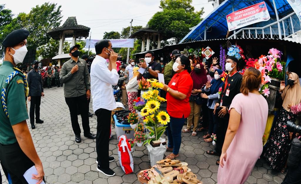 Presiden Joko Widodo (Jokowi) menyapa para pedagang yang tengah berjualan di Pasar Umum Purwodadi, Jawa Tengah, Rabu (5/1/2022).