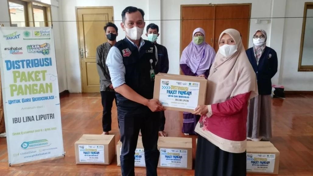 Helliana guru honorer SMP IT Baitul Anshor saat menerima paket pangan Ramadan dari dermawan. (Foto: MNC Media)
