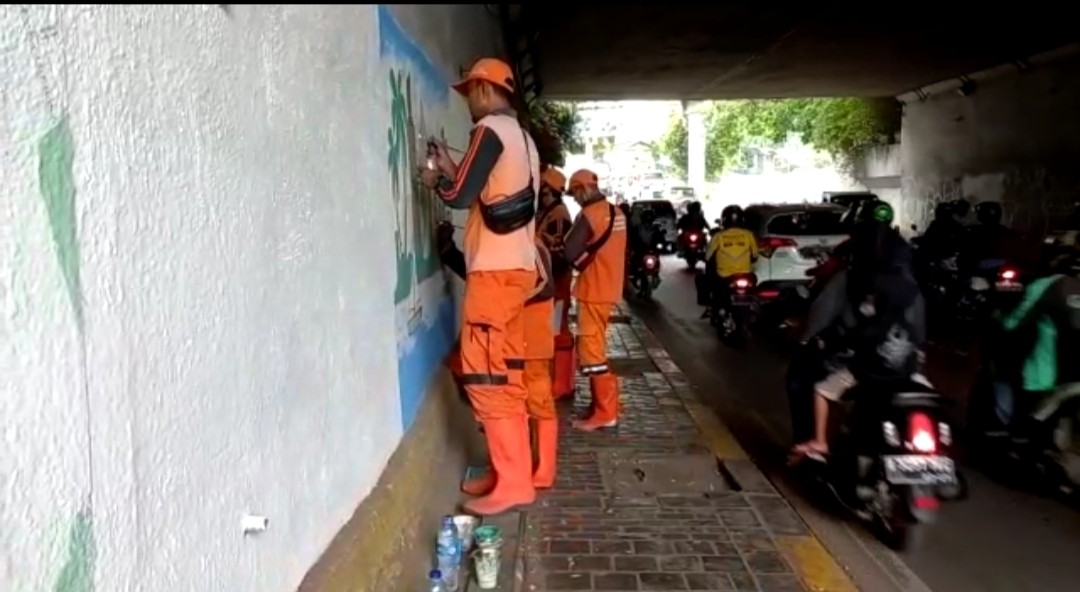 Dalam Rangka Merayakan HUT Jakarta ke-495, Petugas PPSU Manggarai, Jakarta Selatan memperindah tembok terowongan Manggarai dengan menggambar Mural