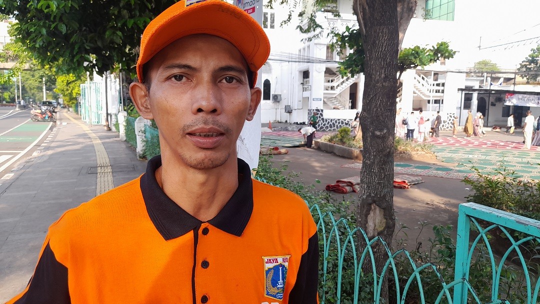 Pasukan Oranye Ini Tetap Semangat Bersihkan Jakarta di Tengah Gema Takbir. (Foto Danandaya Arya/MPI)