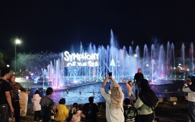 Pengunjung berfoto-foto sembari menunggu pesta kembang api di Ancol Jakarta Utara pada Minggu (31/12/2023) (Carlos/MPI)