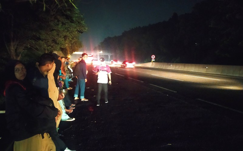 Penumpang menunggu bus di pinggir jalan tol karena rest area KM 125 Tol Purbaleunyi, padat (Ferry Bangkit/MPI)