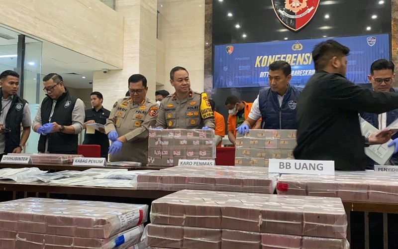 Polisi memamerkan tumpukan uang Rp32 miliar hasil bongkar kasus manipulasi email perusahaan Singapura. (Riana Rizki/MPI)