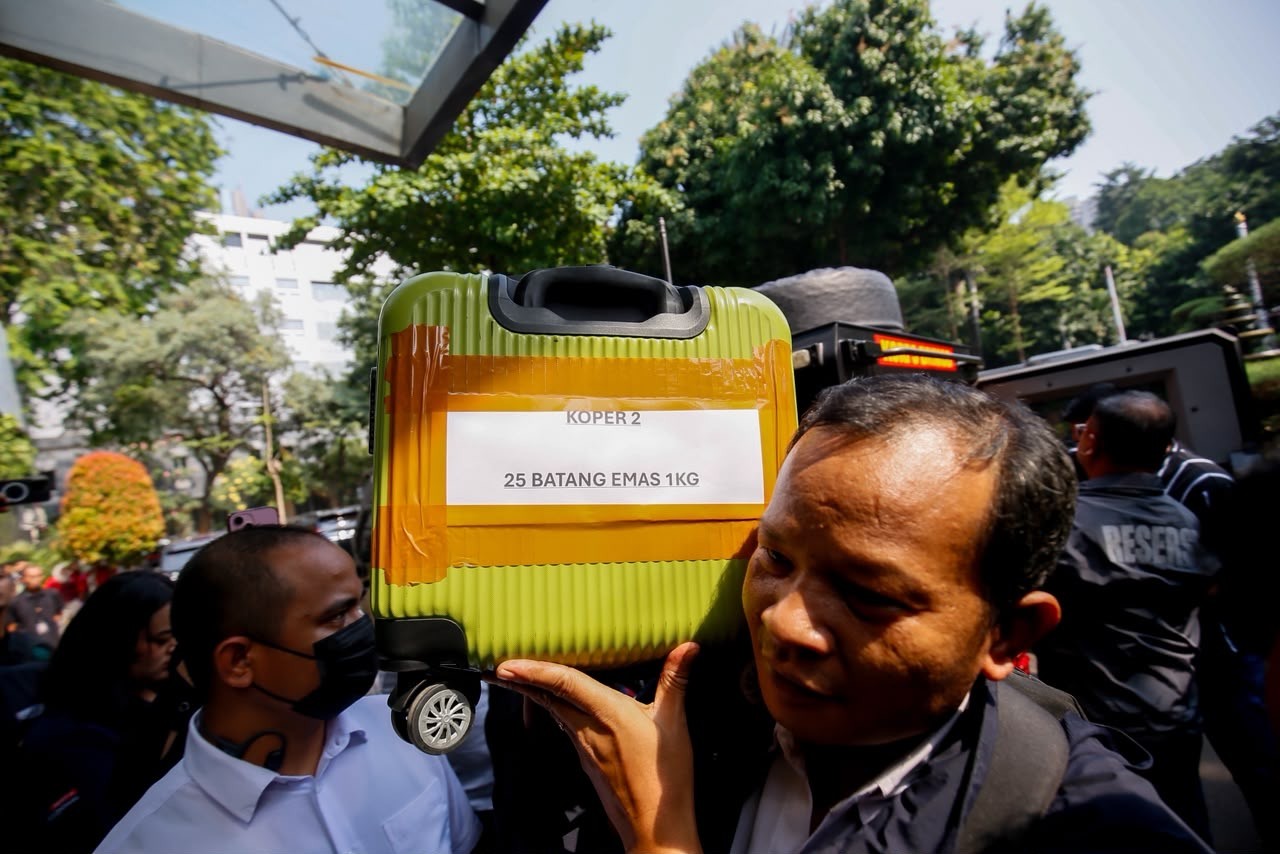 Petugas Kepolisian Kewalahan saat Gotong Koper Isi 74 Kg Emas Batangan Hasil Sitaan. (Foto: MNC Media)