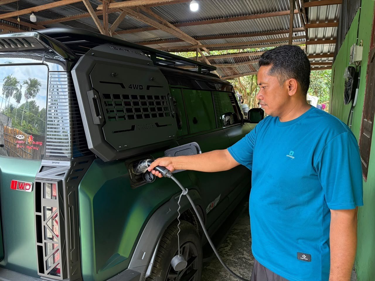 Pelanggan HCS PLN sedang melakukan pengisian daya kendaraan listrik di rumahnya. Foto: dok. PLN.