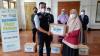Helliana guru honorer SMP IT Baitul Anshor saat menerima paket pangan Ramadan dari dermawan. (Foto: MNC Media)