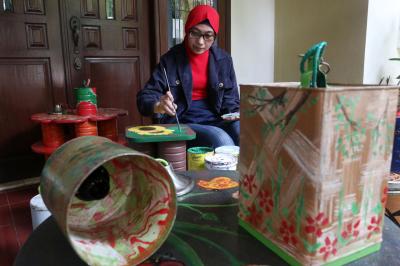 Perajin menyelesaikan pembuatan pot bunga dari kaleng bekas