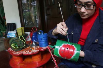 Perajin menyelesaikan pembuatan pot bunga dari kaleng bekas