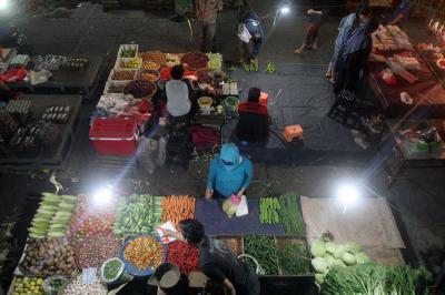 Pedagang dan pembeli beraktivitas di Pasar Kramat Jati, Jakarta Timur, Sabtu (27/2/2021) malam.