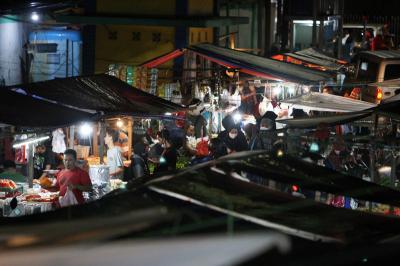 Pedagang dan pembeli beraktivitas di Pasar Kramat Jati, Jakarta Timur, Sabtu (27/2/2021) malam.