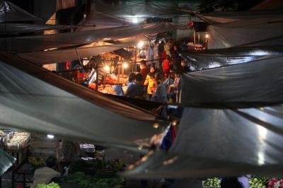 Pedagang dan pembeli beraktivitas di Pasar Kramat Jati, Jakarta Timur, Sabtu (27/2/2021) malam.