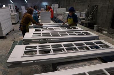 Pekerja menyelesaikan pembuatan lemari pajangan bertema