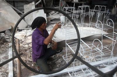 Pekerja sedang menyelesaikan pembuatan rak pot bunga dari besi di kawasan Jalan Kodau, Kota Bekasi, Jawa Barat, Jumat (5/3/2021).