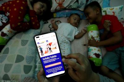 Seorang ibu mencari informasi tentang asuransi kesehatan melalui website AXA Mandiri di Depok, Jawa Barat
