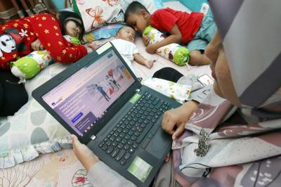Seorang ibu mencari informasi tentang asuransi kesehatan melalui website AXA Mandiri di Depok, Jawa Barat