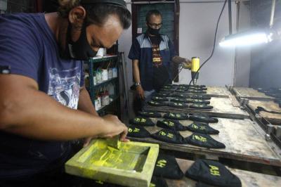 Pekerja membuat masker bersablon di Punya Ku sablon di kawasan Pondok Melati, Kota Bekasi, Jawa Barat, Sabtu (13/3/2021).