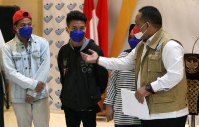 Kepala BP2MI Benny Rhamdani berbincang dengan pekerja migran Indonesia saat memberikan keterangan kepada wartawan di Gedung BP2MI, Jakarta, Senin (15/3/2021).