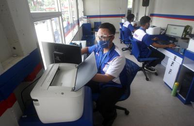 Petugas melayani nasabah untuk melakukan transaksi pengiriman arsip di Jakarta, Rabu (17/3/2021).