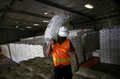 Pekerja membawa stok beras di Gudang Bulog Kanwil DKI dan Banten, Kelapa Gading, Jakarta, Kamis (19/3/2021).