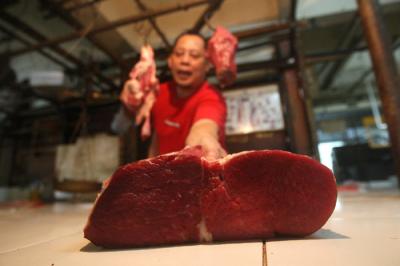 Pedagang memotong daging di Pasar Kramat Jati, Jakarta Timur, Selasa (23/3/2021).
