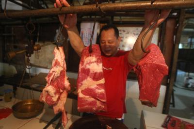 Pedagang merapikan daging di Pasar Kramat Jati, Jakarta Timur, Selasa (23/3/2021).