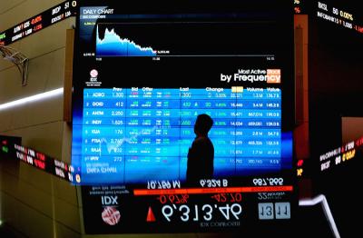Pengunjung melintasi layar bursa saham di Bursa Efek Indonesia (BEI), Jakarta, Rabu (24/3/2021).