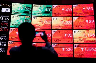 Pengunjung melintasi layar bursa saham di Bursa Efek Indonesia (BEI), Jakarta, Rabu (24/3/2021).