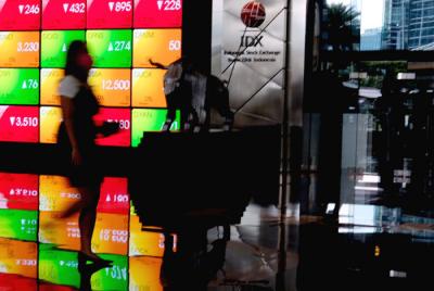 Pengunjung melintasi layar bursa saham di Bursa Efek Indonesia (BEI), Jakarta, Rabu (24/3/2021).