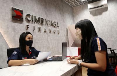 Karyawan melayani nasabah di kantor PT CIMB Niaga Auto Finance (CNAF) di kawasan Bintaro, Tangerang Selatan, Banten, Jumat (26/3/2021).