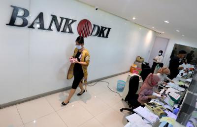 Karyawan menunjukkan uang rupiah di salah satu Kantor Cabang Bank DKI, Jakarta, Jumat (26/3/2021).