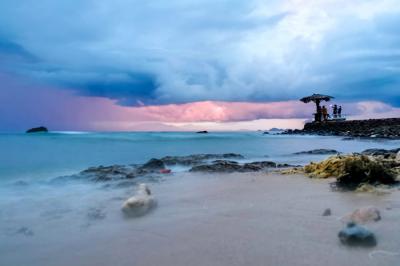Pengunjung menikmati keindahan panorama matahari terbenam di Pantai Anyer, Serang, Banten, Sabtu (27/3/2021).