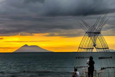 Pengunjung menikmati keindahan panorama matahari terbenam di Pantai Anyer, Serang, Banten, Sabtu (27/3/2021).