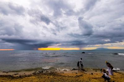 Pengunjung menikmati keindahan panorama matahari terbenam di Pantai Anyer, Serang, Banten, Sabtu (27/3/2021).