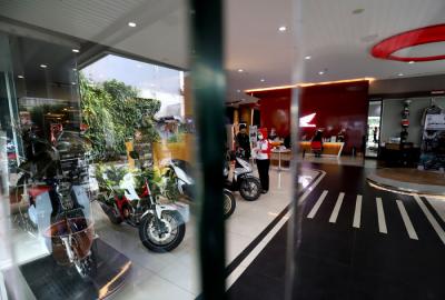 Pekerja melayani calon pembeli sepeda motor di salah satu showroom di Jakarta, Senin (29/3/2021).