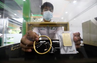 Karyawan menunjukan emas batangan di Kantor Cabang Pengadaian Syariah di kawasan, Jakarta Pusat, Selasa (30/3/2021).