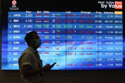 Pengunjung melintasi layar bursa saham di Bursa Efek Indonesia (BEI), Jakarta, Selasa (30/3/2021).