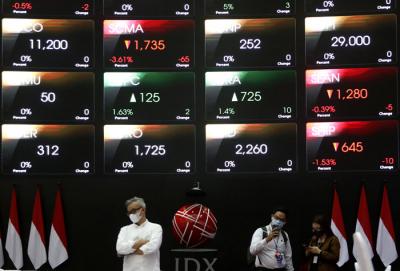 Pengunjung melintasi layar bursa saham di Bursa Efek Indonesia (BEI), Jakarta, Selasa (30/3/2021).