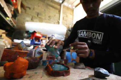 Perajin memasangkan casing atau pelindung telepon genggam dari bahan baku resin di Pondok Cabe, Tangerang Selatan, Banten, Rabu (31/3/2021).
