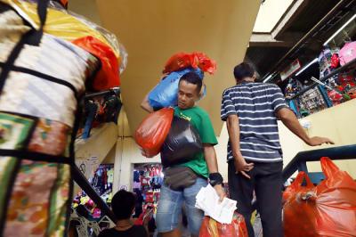 Pedagang mengemas pakaian jadi yang laku terjual di Pusat Grosir Pasar Cipulir, Jakarta, Rabu (31/3/2021).