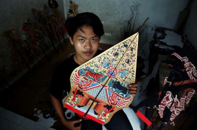 Perajin wayang Ahmad Maiyo Satria Tama (16) menyelesaikan pembuatan dan perbaikan wayang di Surabaya, Jawa Timur, Rabu (31/3/2021).