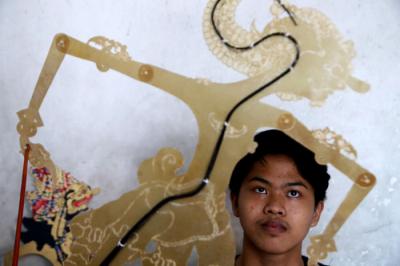 Perajin wayang Ahmad Maiyo Satria Tama (16) menyelesaikan pembuatan dan perbaikan wayang di Surabaya, Jawa Timur, Rabu (31/3/2021).