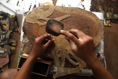 Perajin wayang Ahmad Maiyo Satria Tama (16) menyelesaikan pembuatan dan perbaikan wayang di Surabaya, Jawa Timur, Rabu (31/3/2021).