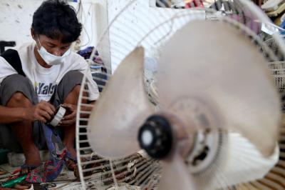 Tukang servis kipas angin, Musyafak menyelesaikan perbaikan kipas angin di Pasar Loak Gembong Surabaya, Jawa Timur, Kamis (1/4/2021).