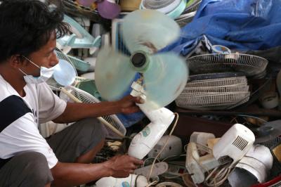 Tukang servis kipas angin, Musyafak menyelesaikan perbaikan kipas angin di Pasar Loak Gembong Surabaya, Jawa Timur, Kamis (1/4/2021).
