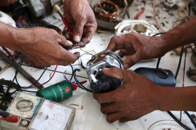 Tukang servis kipas angin, Musyafak menyelesaikan perbaikan kipas angin di Pasar Loak Gembong Surabaya, Jawa Timur, Kamis (1/4/2021).