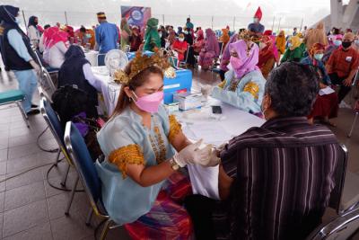 Tim medis dan peserta vaksinasi berpakaian baju adat mengikuti Festival Smart Vaksinasi Makassar di Makassar, Sulawesi Selatan, Kamis (1/4/2021).