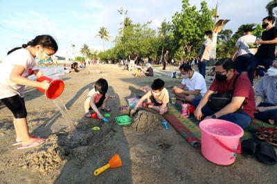 Pengunjung bermain di Pantai Indah Ancol di Jakarta, Jumat (2/4/2021).